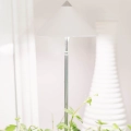 Elegante SUNLiTE 7W LED Pflanzenlampe in Weiß. Der minimalistische Lampenschirm und der schlanke Teleskopstab fügen sich stilvoll in eine helle Wohnzimmer-Einrichtung ein.