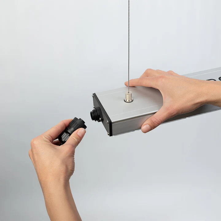 Hände verbinden eine hochwertige, wasserdichte Hirschmann-Kupplung mit der VEGA Pro LED Pflanzenlampe. Zeigt die einfache und sichere Montage.